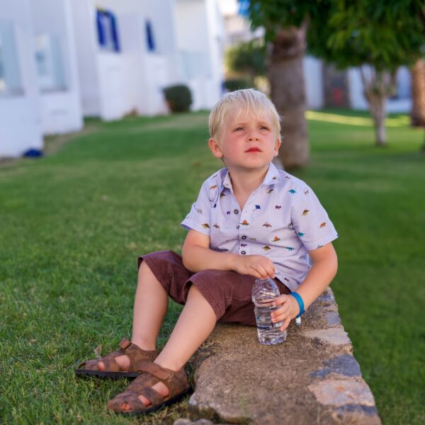 A little boy sat on a wall in Crete, looking longly in the distance.