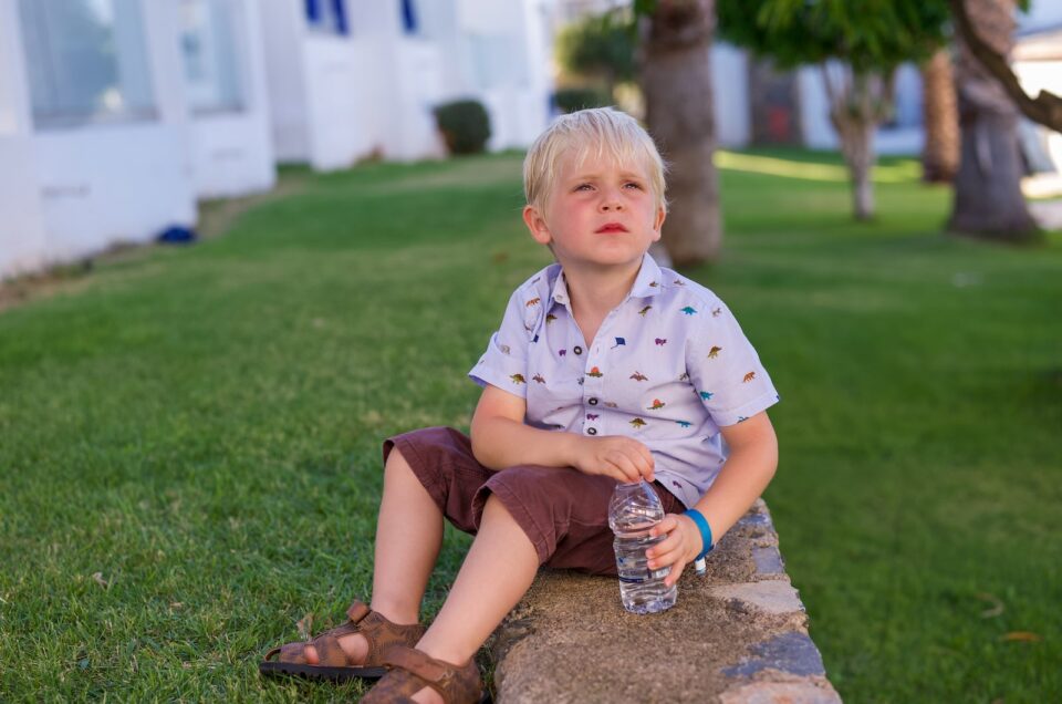 A little boy sat on a wall in Crete, looking longly in the distance.