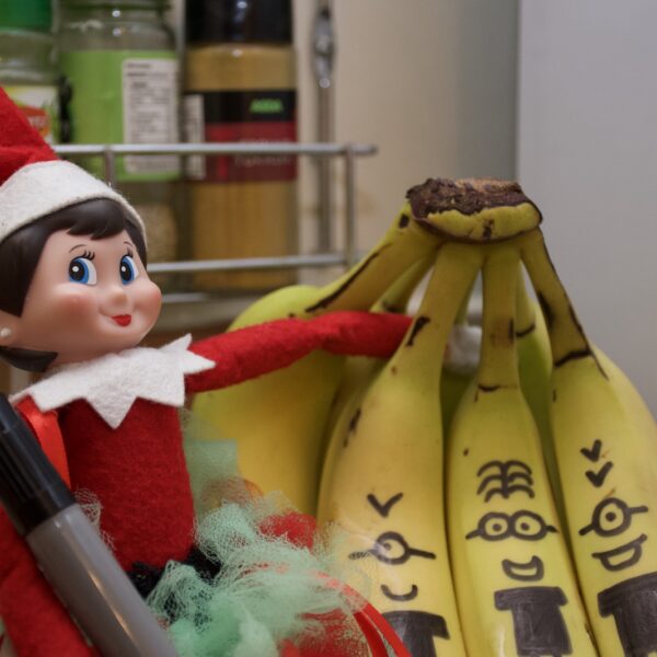 An elf that has written funny faces on bananas.