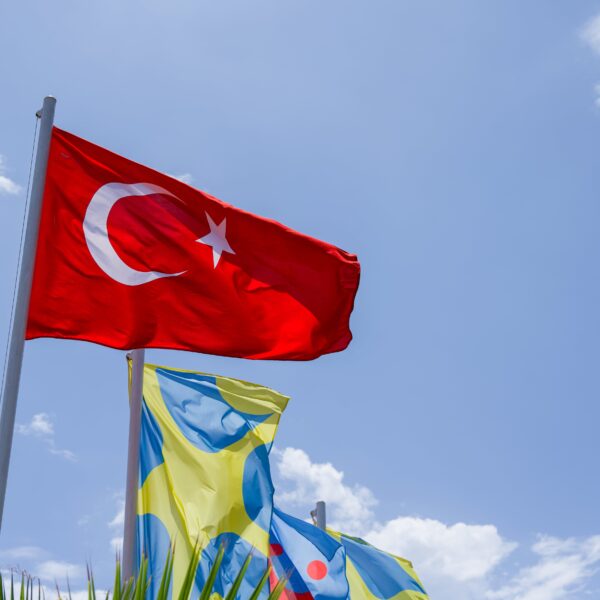 The Turkey flag flying on a blue sky background.