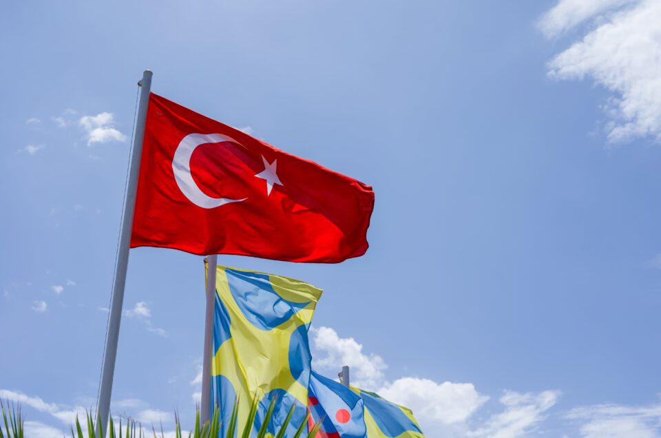 The Turkey flag flying on a blue sky background.